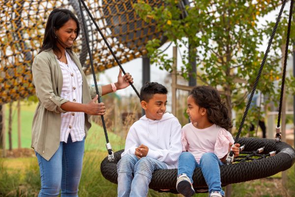 Two children and a parent enjoying the playspace