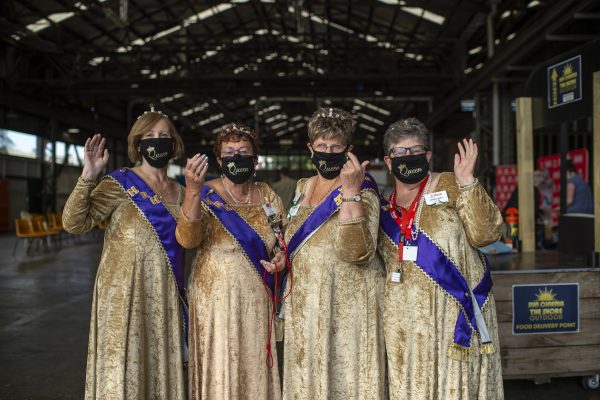 Four women in matching costumes and masks.