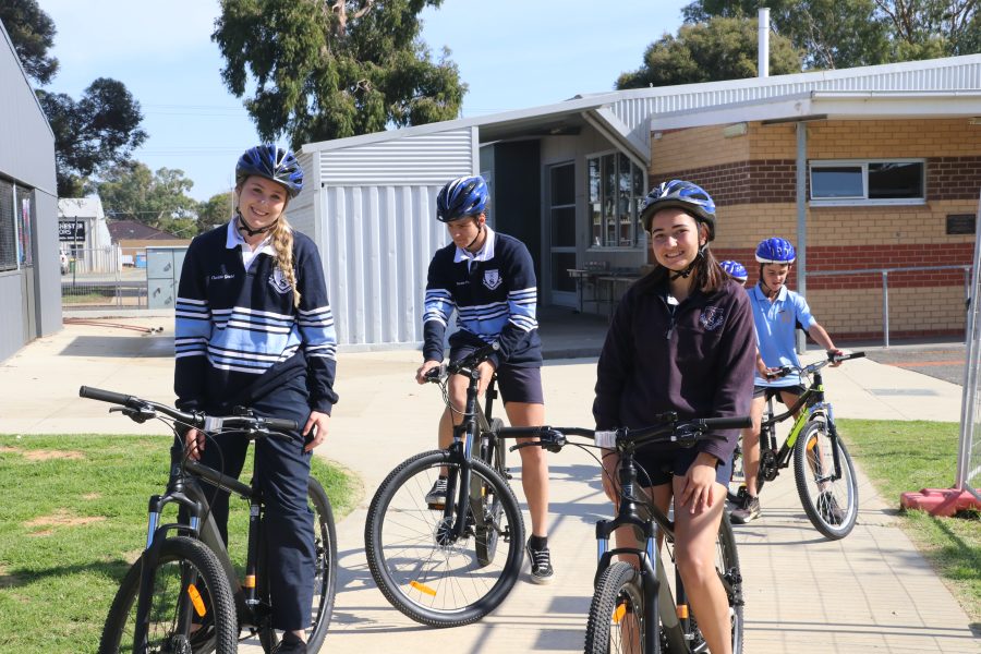 Four students pose on their new bikes